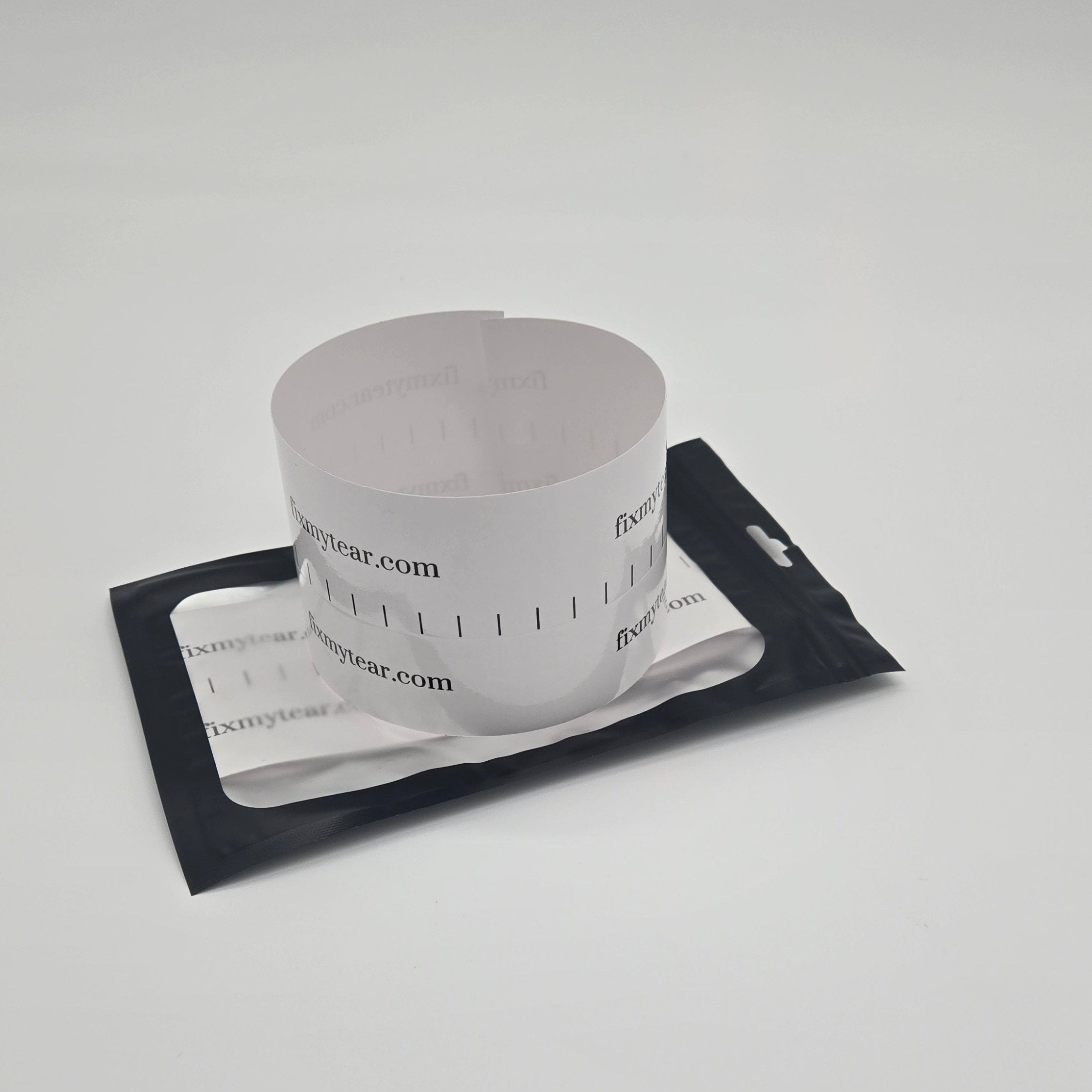 A Fix My Tear Magic Patch, appearing as a white patch with printed text, placed on a black surface.